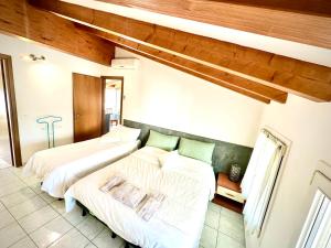 two beds in a bedroom with wooden ceilings at Open space centre in Lignano Sabbiadoro