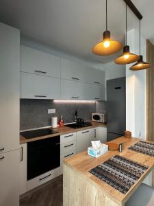 a kitchen with white cabinets and a wooden counter top at Lake On Exclusive in Mamaia