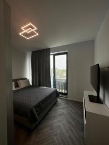 a bedroom with a bed and a television and a window at Lake On Exclusive in Mamaia