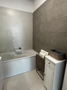 a white bathroom with a tub and a sink at Lake On Exclusive in Mamaia +4 photos