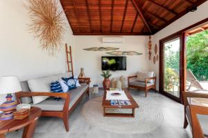 a living room with a couch and a table at Tua Pousada Boutique Tatuamunha, Rota Ecológica dos Milagres, Porto de Pedras, Alagoas in Tatuamunha