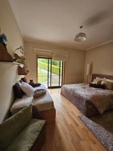 een slaapkamer met 2 bedden en een bank bij Casa da Aldeia 