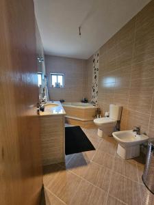 een badkamer met 2 wastafels, een toilet en een bad bij Casa da Aldeia 