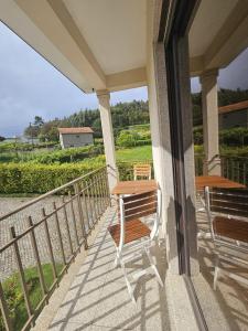 een veranda met 2 stoelen en een tafel. bij Casa da Aldeia 