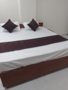 un letto con lenzuola e cuscini bianchi e neri di Mayura palace a Jaipur