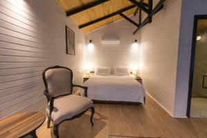 ein Schlafzimmer mit einem Bett und einem Stuhl darin in der Unterkunft Dedeman Village Cappadocia in Goreme + 10 Fotos