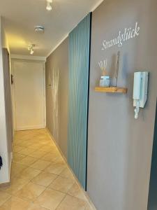 einen Flur mit Münztelefon an der Wand in der Unterkunft Tannenburg 206 "Strandglück" in Grömitz