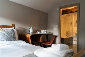 a bedroom with a bed and a desk with a shower at The Milestone in Sowerby Bridge