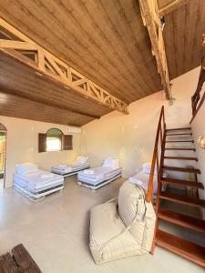 a room with three beds and a staircase at Matteo & Matteo Hostel Boutique in Pipa