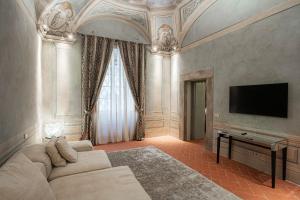 een woonkamer met een bank en een flatscreen-tv bij Prestigioso Palazzo Fiorentino in Florence