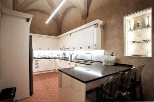 een keuken met witte kasten en een zwart aanrechtblad bij Prestigioso Palazzo Fiorentino in Florence