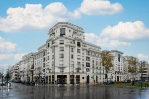 a large white building on a rainy street at Luxueux Appartement Design 70m2 Disneyland Paris pour 6pax in Chessy
