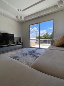 een slaapkamer met een groot bed en een groot raam bij Apto centro de Ametista do Sul 2 dorm in Ametista do Sul