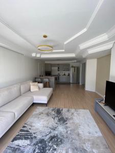 een woonkamer met een witte bank en een televisie bij Apto centro de Ametista do Sul 2 dorm in Ametista do Sul