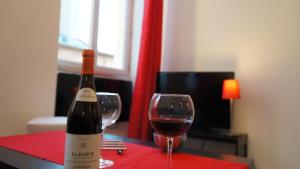 a bottle of wine and a glass on a table at Le Vinéa in Beaune +5 photos