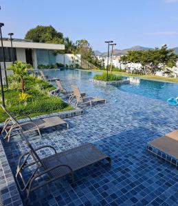 a swimming pool with lounge chairs in a resort at Vista Mar Icaraí Ingá in Niterói