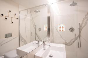 ein weißes Badezimmer mit Waschbecken und Dusche in der Unterkunft Romantica Suite nel cuore Firenze in Florenz