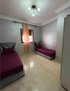 een kamer met twee bedden en een raam bij Résidence Al Manadir Agadir in Aourir
