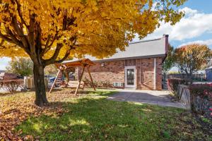 ein Baum mit einer Schaukel vor einem Gebäude in der Unterkunft HomeTowne Studios by Red Roof Georgetown, KY in Georgetown