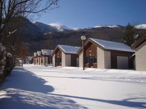 a snow covered street with a row of buildings at Le Pas de L'Ours in Aston