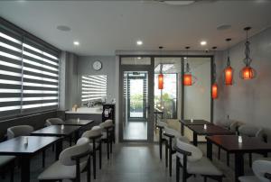 een restaurant met houten tafels en stoelen en een klok bij Annam Saigon Home in Ho Chi Minh-stad