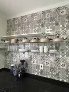 een keuken met een betegelde muur met potten en pannen bij Casa Cacau in Ubatuba +9 foto's