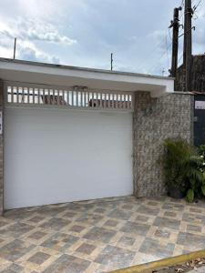 een witte garagedeur aan de zijkant van een huis bij Casa Cacau in Ubatuba
