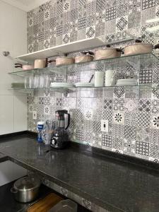 een keuken met een aanrecht en een tegelwand bij Casa Cacau in Ubatuba