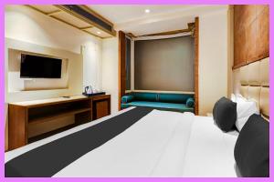 ein Hotelzimmer mit Bett und Fernseher in der Unterkunft Hotel Kavira Palace Inn in Bhubaneshwar