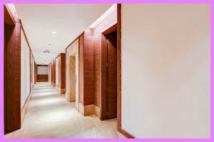 ein Flur mit Holzvertäfelung und weißer Wand in der Unterkunft Hotel Kavira Palace Inn in Bhubaneshwar