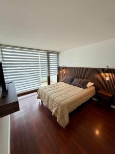 een slaapkamer met een groot bed en een groot raam bij Sky Park Elite in Santiago +14 foto's