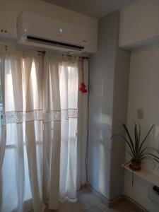 een raam met witte gordijnen in een kamer bij Monoambiente Avellaneda Barrio Norte in San Miguel de Tucumán