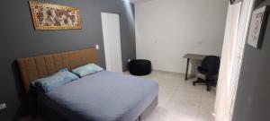 a small bedroom with a bed and a desk at Cintra Home Araçariguama - Casa 04 in Araçariguama