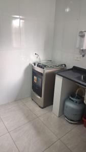 a kitchen with a stove top oven in a room at Cintra Home Araçariguama - Casa 04 in Araçariguama