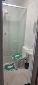 a bathroom with a toilet and a glass shower at Cintra Home Araçariguama - Casa 04 in Araçariguama