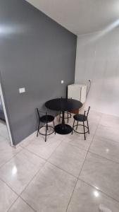 a black table and chairs in a room at Cintra Home Araçariguama - Casa 04 in Araçariguama +1 photo