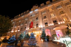 ein großes Gebäude mit Weihnachtsbäumen davor in der Unterkunft Boscolo Nice Hotel & Spa in Nizza