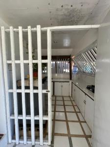 a white bunk bed in a room with a kitchen at Casa Alegria Beach Rooms in Alegria