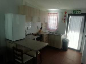 een keuken met een witte koelkast en een tafel bij PauMar Guesthouse in Sutherland +7 foto's