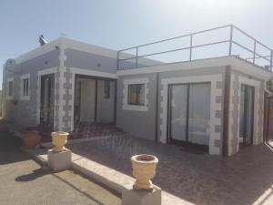 een huis met twee vazen ervoor bij PauMar Guesthouse in Sutherland