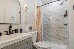 een badkamer met een wastafel, een toilet en een douche bij Cozy 4BR Retreat - Private backyard, Gazebo & Grill in Fairfax +36 foto's