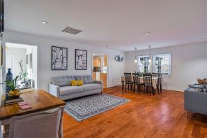 een woonkamer met een bank en een tafel bij Cozy 4BR Retreat - Private backyard, Gazebo & Grill in Fairfax