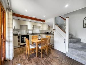 een keuken met een eettafel en stoelen bij Pilsbury Cottage in Luppitt