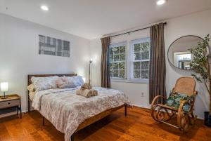 een slaapkamer met een bed, een stoel en een spiegel bij Cozy 4BR Retreat - Private backyard, Gazebo & Grill in Fairfax