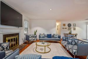 een woonkamer met blauwe banken en een open haard bij Cozy 4BR Retreat - Private backyard, Gazebo & Grill in Fairfax