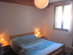 una camera da letto con un letto con due lampade e una finestra di les Beraudes 1 a Névache