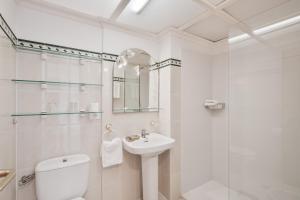 een witte badkamer met een toilet en een wastafel bij Playa Delphin 105 in Puerto Naos