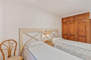 een slaapkamer met 2 bedden en een houten kast bij Playa Delphin 105 in Puerto Naos