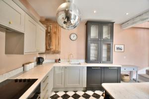 a kitchen with white cabinets and a clock on the wall at 1 Purfleet Quay in King's Lynn +23 photos