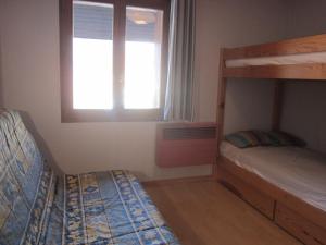 una camera da letto con due letti a castello e una finestra di les Beraudes 1 a Névache